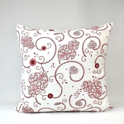Almofada branca com padrão castanho-avermelhado de flores e arabescos
