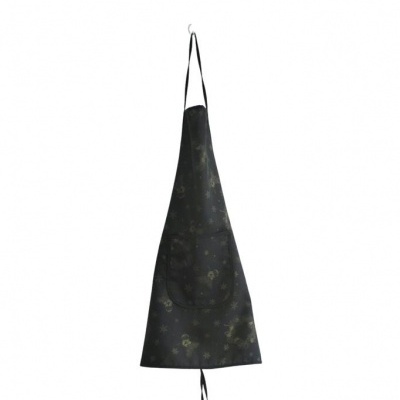 Avental preto com padrão dourado e bolso frontal pendurado num gancho