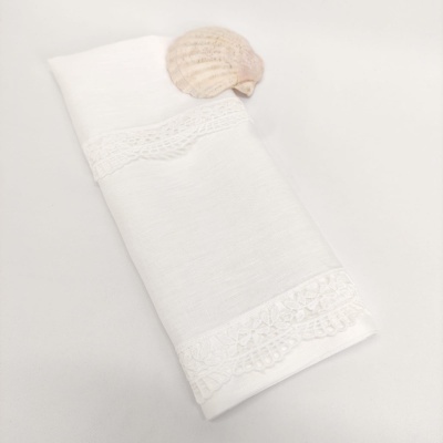 Toalha branca com renda e concha marinha