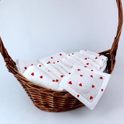 Toalhetes brancos com corações vermelhos em cesto de vime