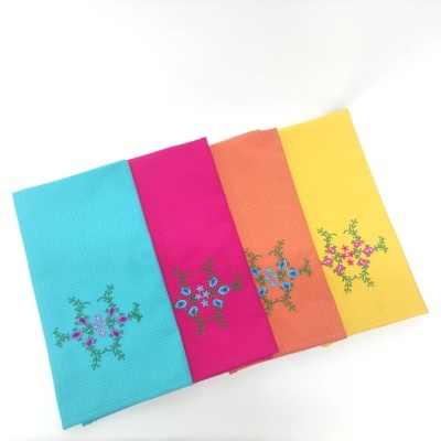 Quatro toalhas coloridas com bordados florais