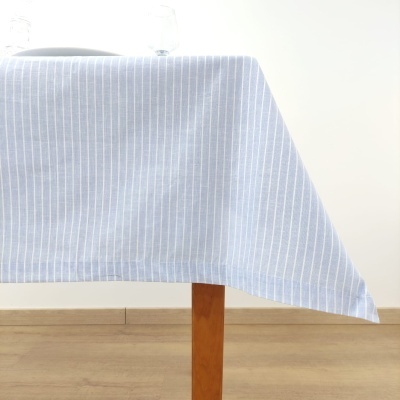 Toalha de mesa azul com riscas brancas sobre mesa de madeira clara