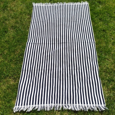 Tapete ou toalha de praia riscada azul escuro e branca com franjas em relva