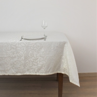 Mesa com toalha branca decorativa com prato, talheres e copo