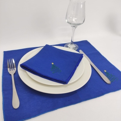 Conjunto de mesa azul com bordado de árvore de Natal, pratos brancos, talheres e copo de vidro
