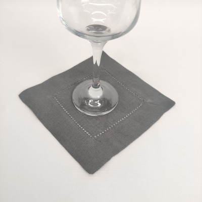 Guardanapo cinzento tecido com copo de vidro por cima