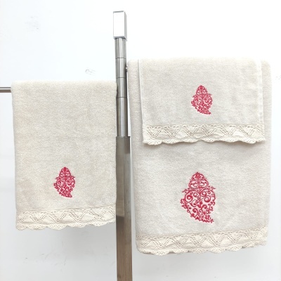 Conjunto de toalhas bege com bordados vermelhos e renda
