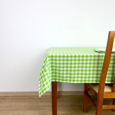 Toalha de mesa xadrez verde e branca numa mesa de madeira com cadeira