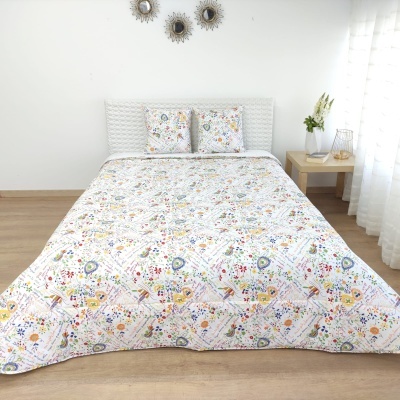 Conjunto de cama com colcha e almofadas florais coloridas em quarto claro e moderno