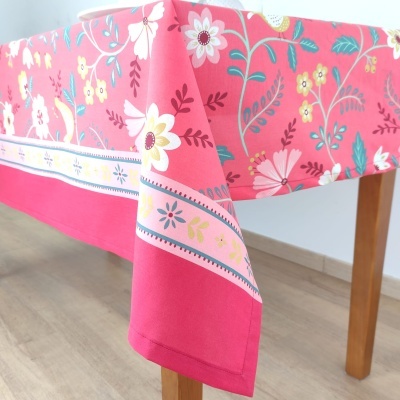 toalha de mesa rosa com padrão floral em mesa de madeira