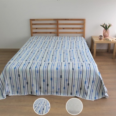 Colcha branca com padrão azul em cama de madeira clara num quarto minimalista