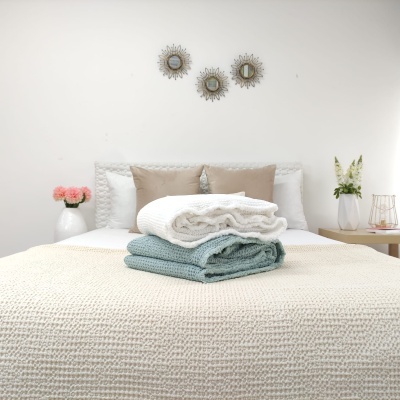 Conjunto de mantas de malha sobre cama em quarto decorado minimalista