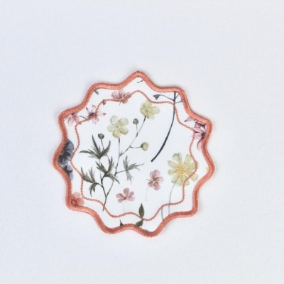 Etiqueta têxtil com flores estilizadas em tecido branco