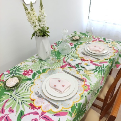 Mesa posta com toalha floral e guarda-napos bordados numa sala clara