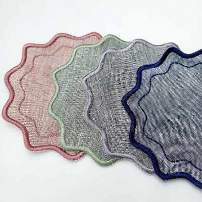 Quatro tecidos decorativos com bordas onduladas em várias cores sobre fundo branco