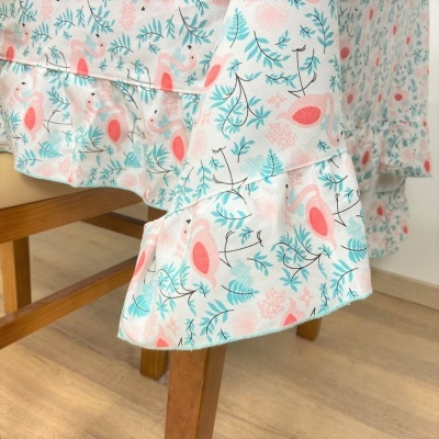 Toalha de mesa com padrão floral azul e cor-de-rosa em mesa de madeira