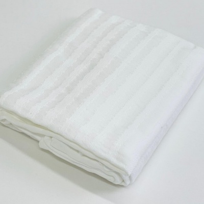 Toalha branca dobrada com textura às riscas