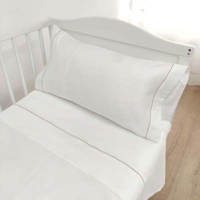Roupa de cama branca com bordas bege num berço branco de madeira