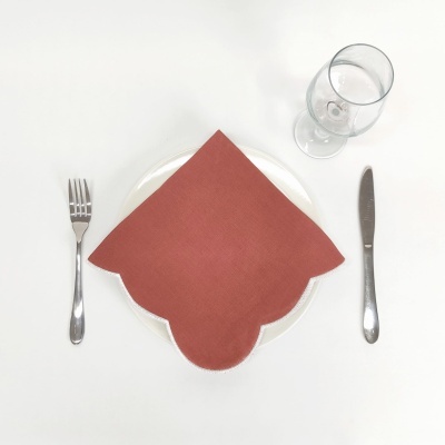 Conjunto de talheres em aço inoxidável com prato branco, guardanapo laranja e copo de vidro