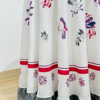 Manta redonda com padrão de pássaros e folhas e babados cinzentos