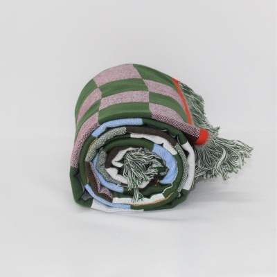 Manta enrolada com padrão xadrez e franjas