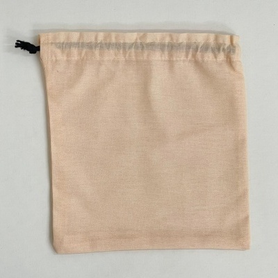 Saco de tecido bege com cordão preto sobre superfície branca