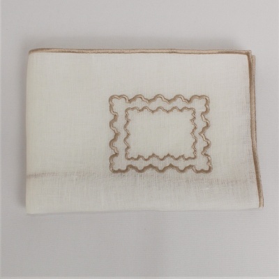 Guardanapo de tecido branco com bordado bege e molduras retangulares no centro