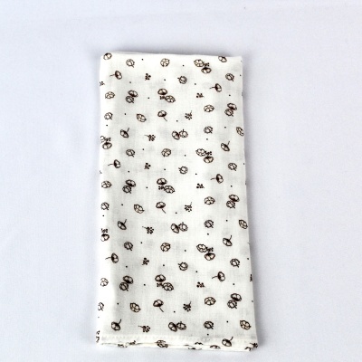 Toalha branca com padrão de pequenas flores pretas dobrada