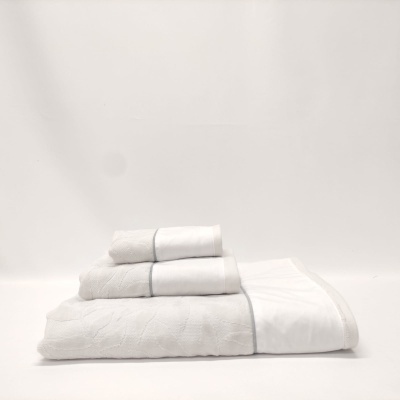 Conjunto de toalhas brancas empilhadas com texturas bordadas