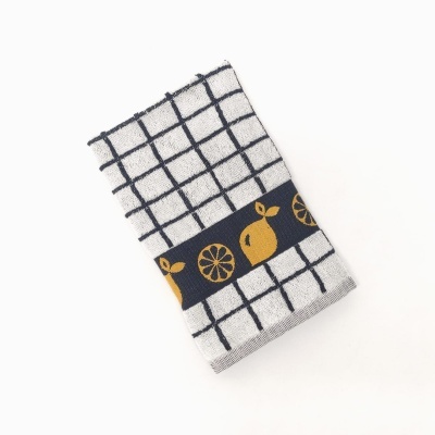 Pano de cozinha cinza com padrão de quadrados pretos e faixa com citrinos amarelos