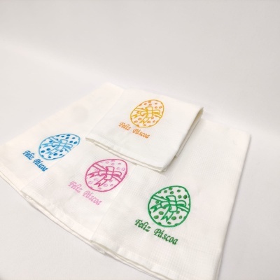 Quatro panos de cozinha brancos com desenhos coloridos de ovo da Páscoa e texto 'Feliz Páscoa'