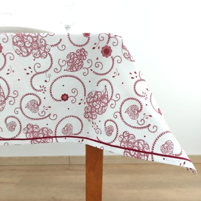 Toalha de mesa branca com padrão vermelho sobre mesa de madeira