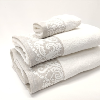 Três toalhas brancas com padrão floral cinza claro nas bordas empilhadas