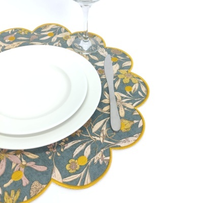 Jogo americano floral ondulado com pratos brancos e faca metálica