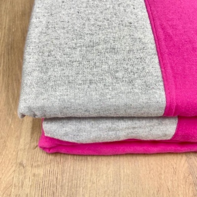 tecido cinzento e rosa dobrado sobre madeira