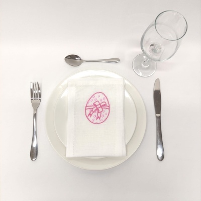 Conjunto de talheres e prato branco com toalha bordada e taça de vinho