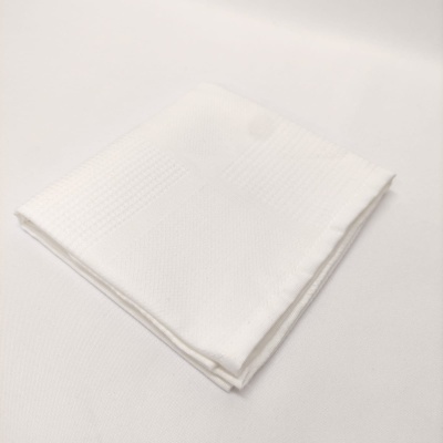 Guardanapo de tecido branco dobrado em superfície branca