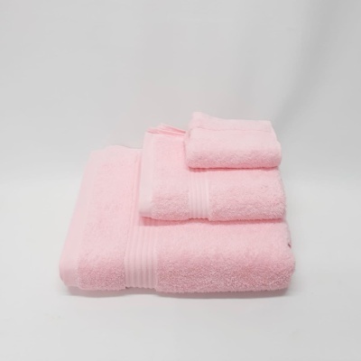 Conjunto de toalhas cor-de-rosa empilhadas sobre fundo branco