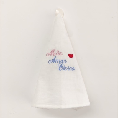 Pano de cozinha branco com bordado colorido pendurado na parede