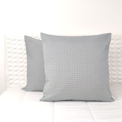 Dois almofadas cinza claro com padrão quadriculado sobre colchão branco