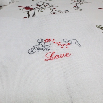 Toalha branca bordada com desenho de crianças e palavra 'Love'