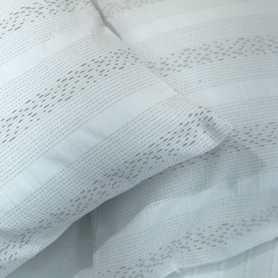 Almofadas brancas com padrão de linhas pequenas e perfuradas