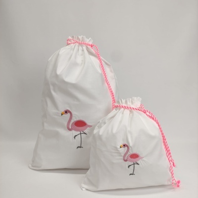 Duas bolsas de tecido branco com cordão rosa e desenho de flamingo rosa
