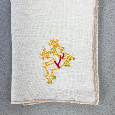 Pano bege claro bordado com rena colorida sobre superfície cinza