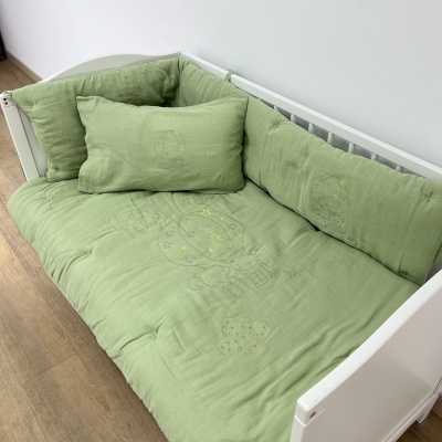 Sofá-cama infantil branco com almofadas verdes acolchoadas bordadas