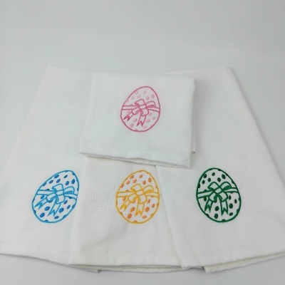 Quatro panos de cozinha brancos com bordados coloridos de ovos de Páscoa