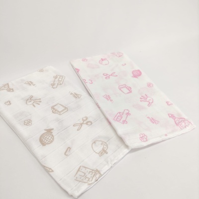 Dois panos de algodão muselina com padrões bege e rosa num fundo branco.