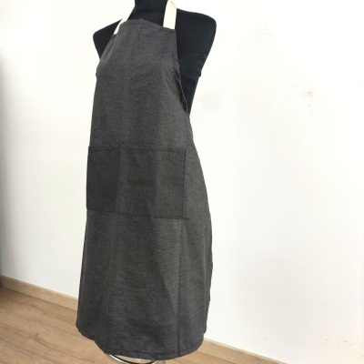 Avental cinza escuro com bolso frontal, alças brancas, numa manequim preta