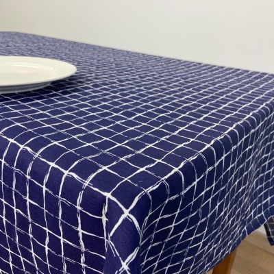 Toalha de mesa azul com padrão de linhas brancas em grelha