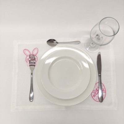 Conjunto de pratos, talheres, copo sobre individual bordado com coelho e ovo de Páscoa